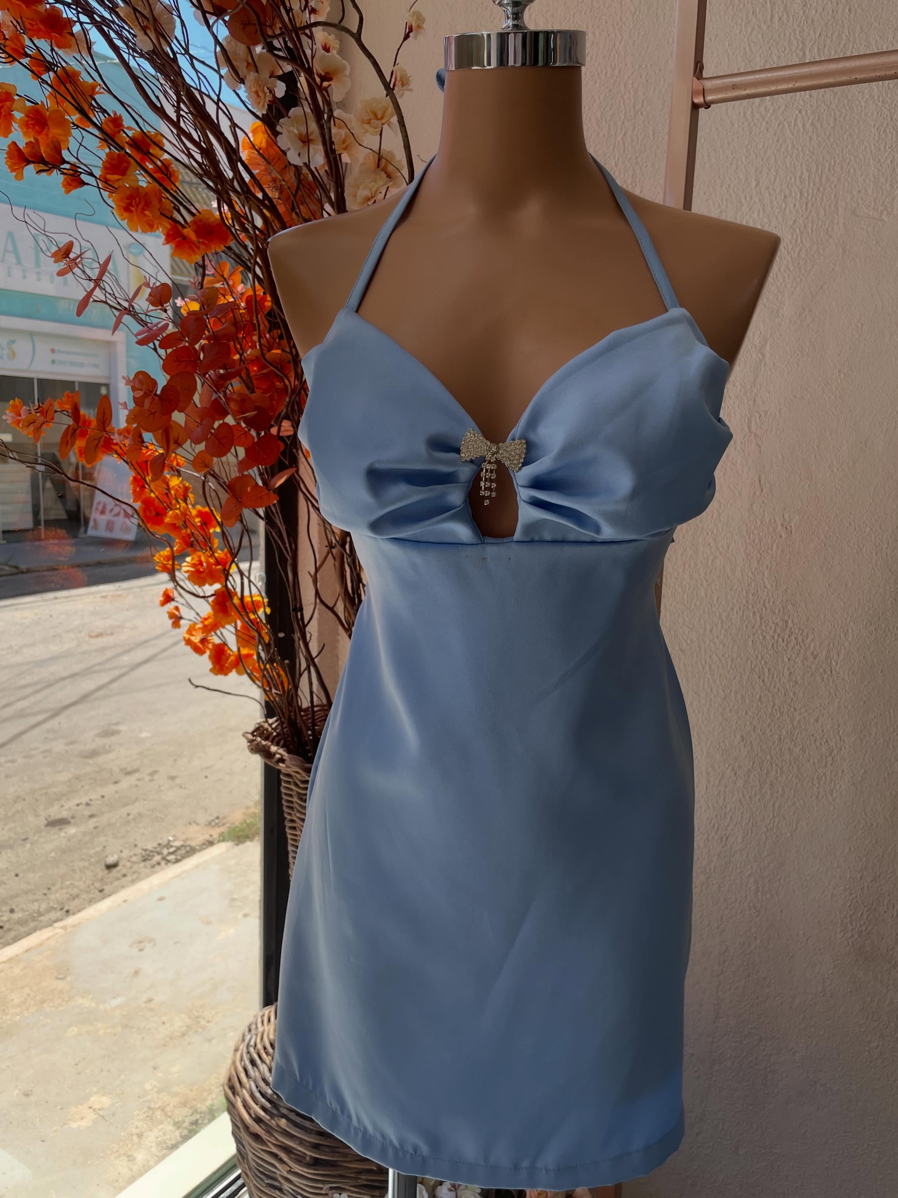 Vestido azul acetinado com laço no busto, no manequim