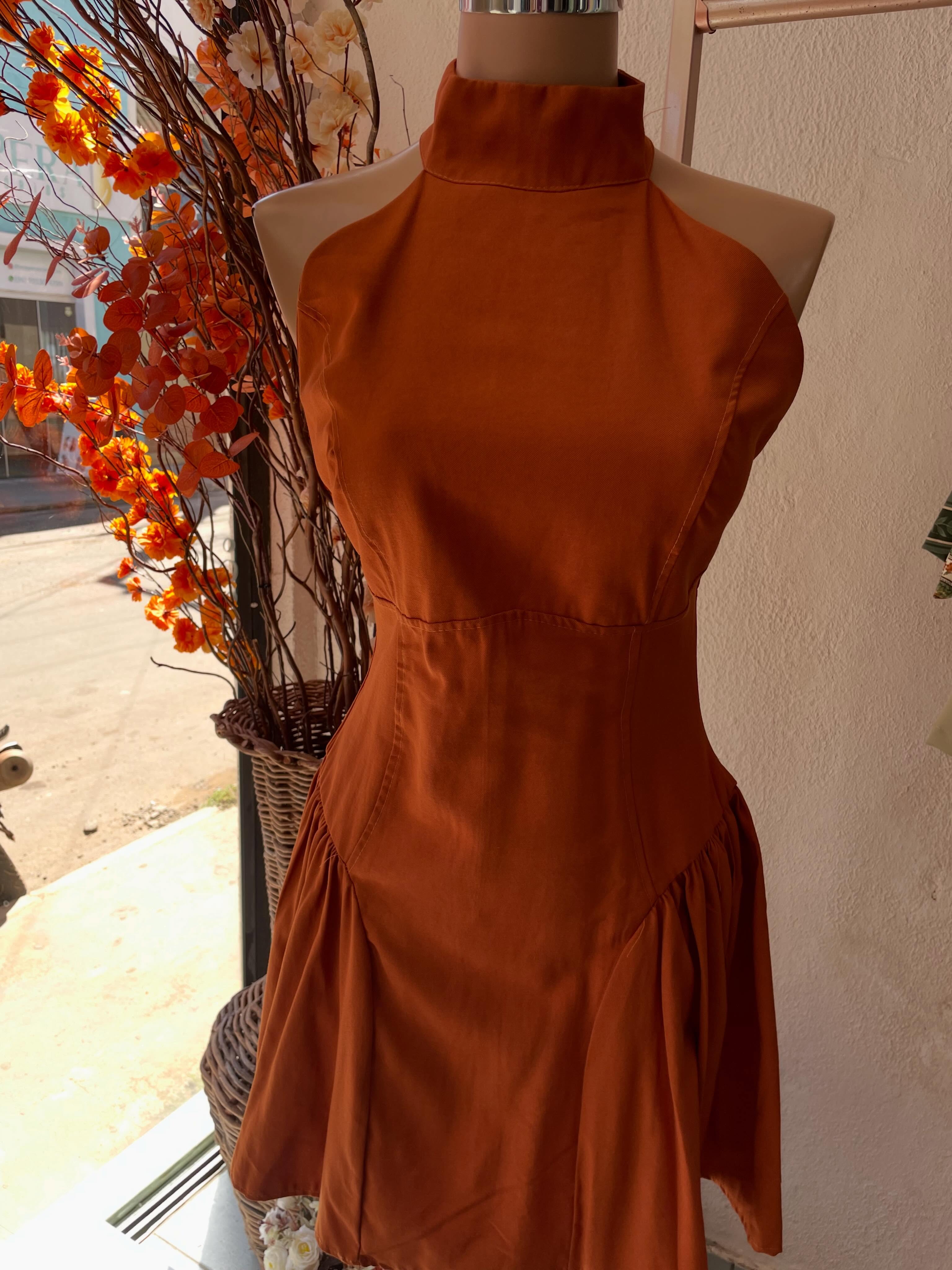 Vestido tom ferrugem de gola alta no manequim