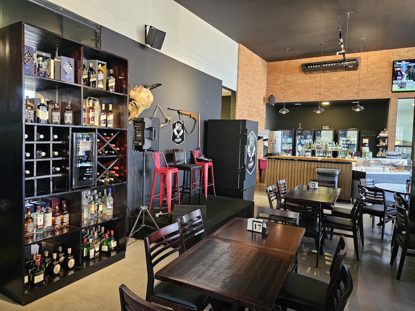 Bar e adega com garrafas e banquetas