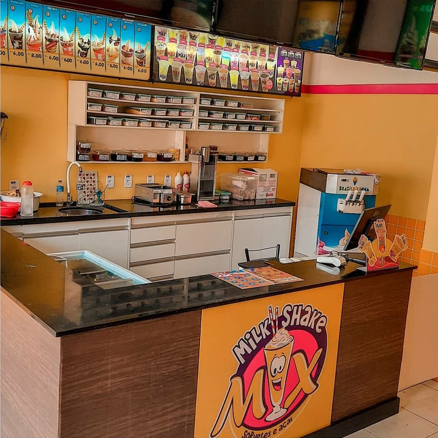 Balcão colorido da Milk Shake Mix com opções de sorvete e açaí