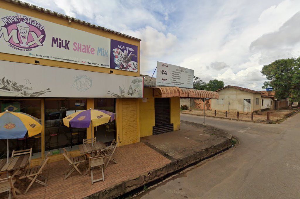Fachada colorida da Milk Shake Mix na esquina, com mesas na calçada