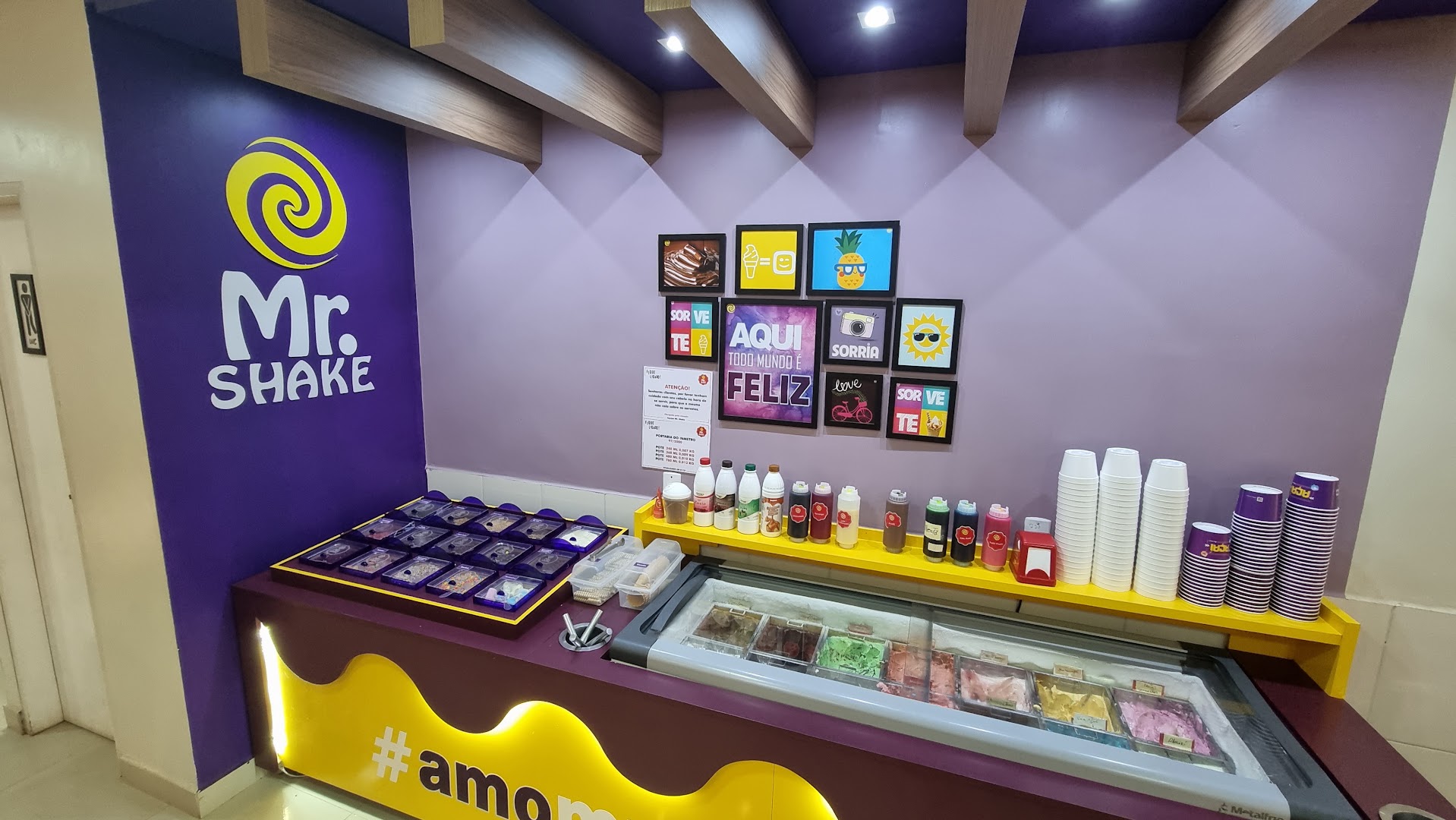 Salão interno em tons de roxo com quadros na parede