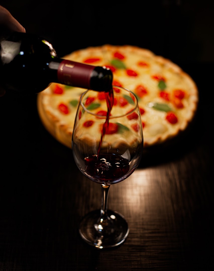Pizza e taça de vinho na Nápoli