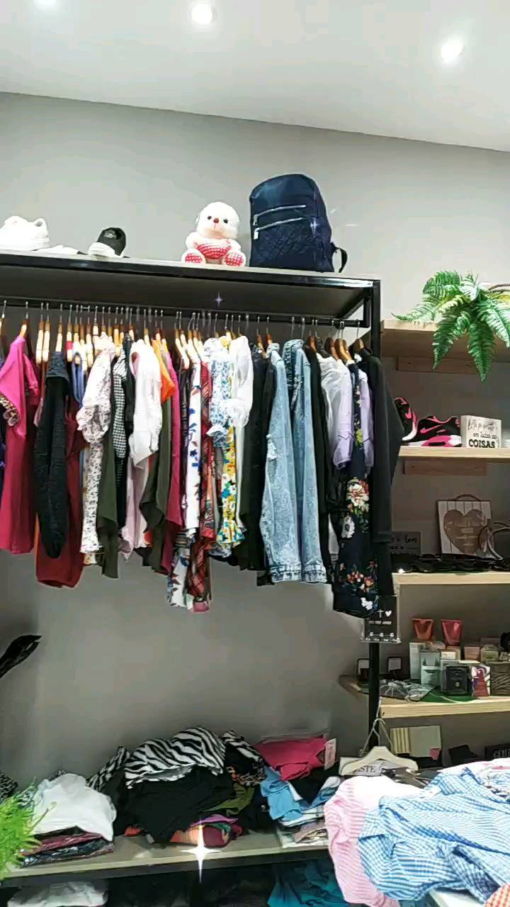 Araras cheias de roupas na loja Naty Store