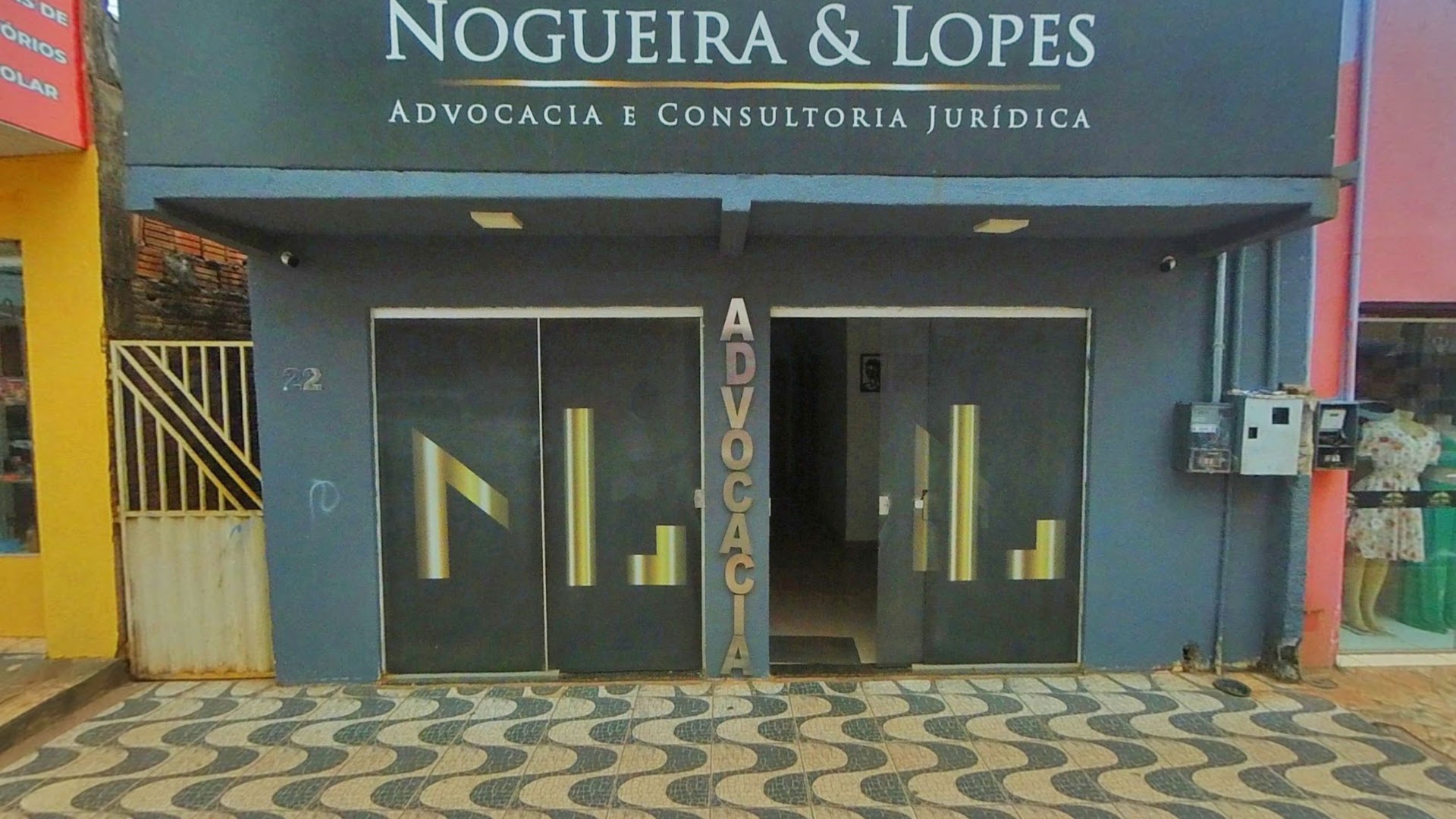 Portas de entrada do escritório com a marca Nogueira e Lopes e a palavra Advocacia