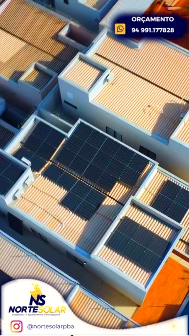 Módulos solares instalados sobre telhados metálicos de casas modernas, vistos de cima