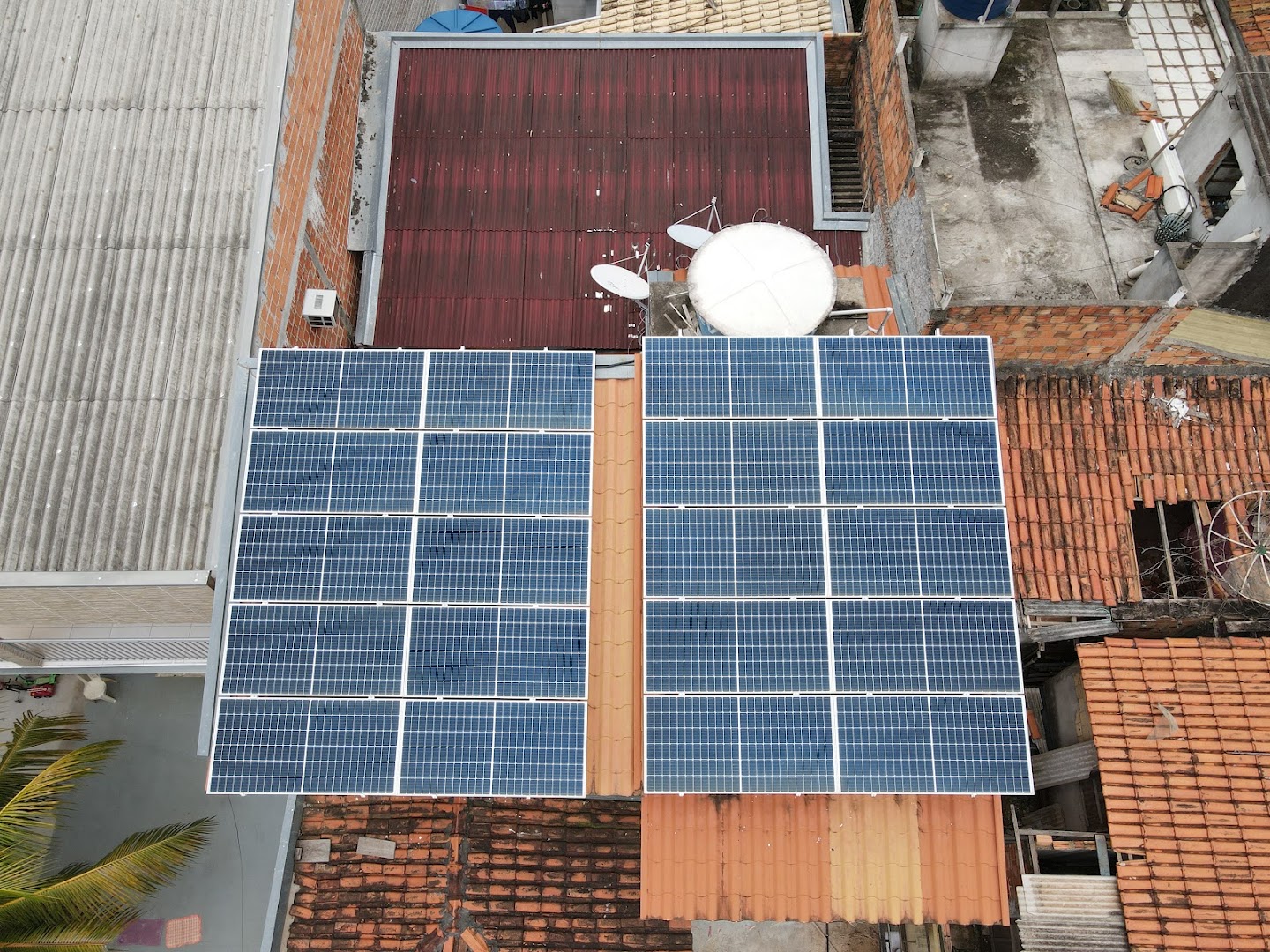 Vista de drone de dois arranjos de módulos solares instalados lado a lado sobre um telhado