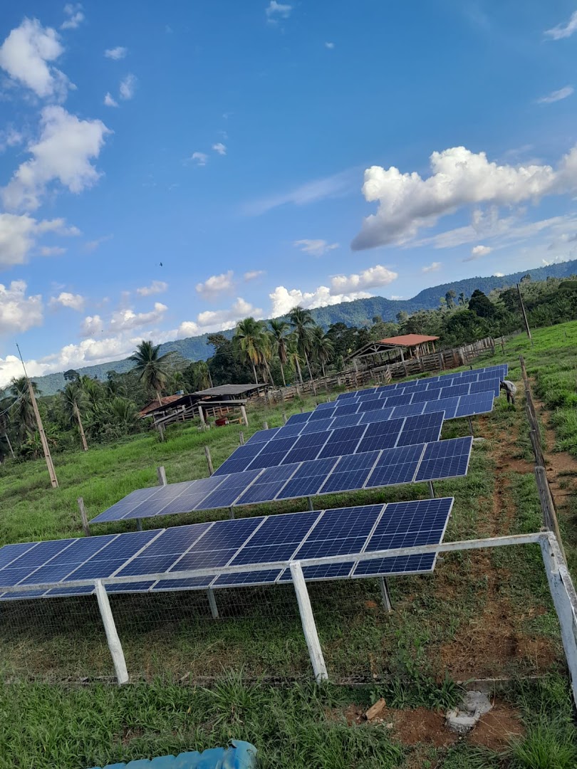Usina solar de solo montada em terreno verde com serra ao fundo