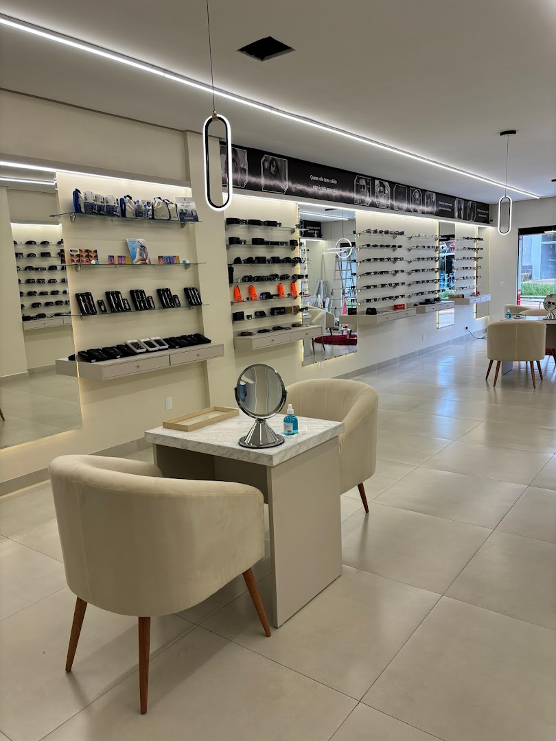 Salão da boutique com poltronas, espelho e paredes de armações