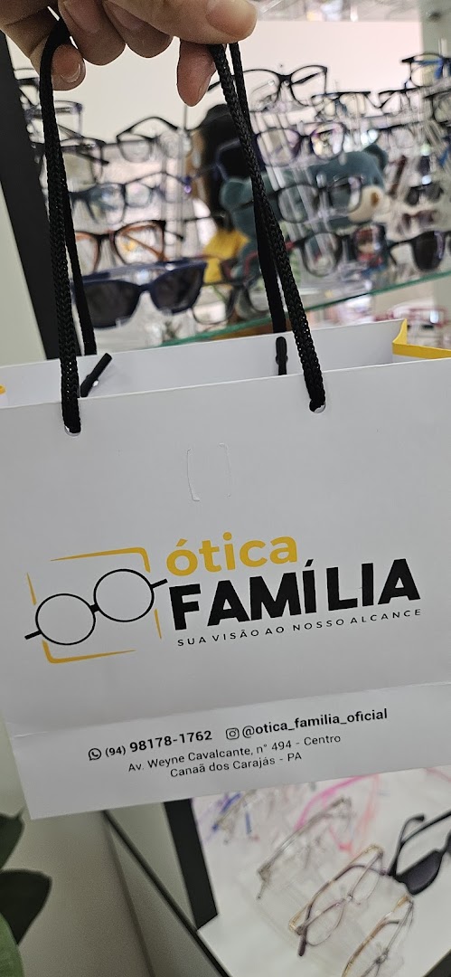 Sacola branca da marca Ótica Família com o logo de óculos