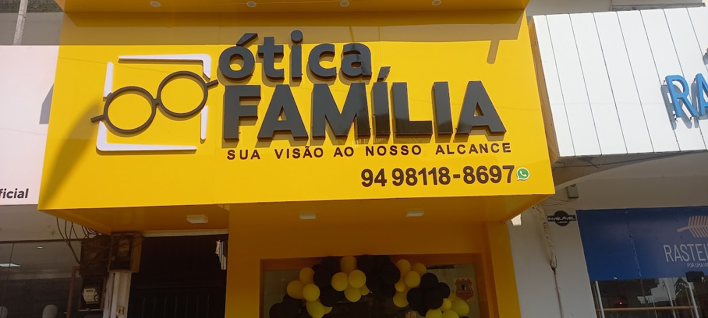 Fachada amarela da Ótica família com o logo de óculos e a placa da loja