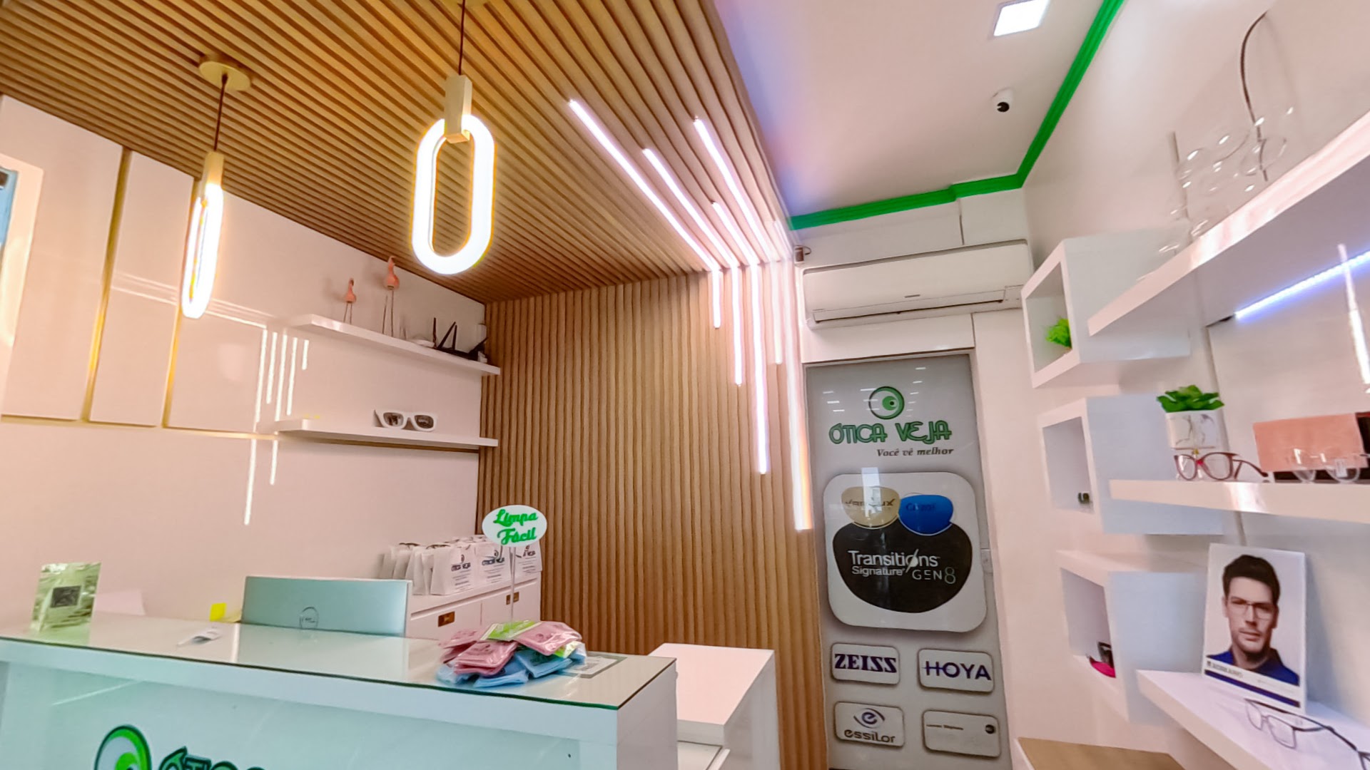 Interior da Ótica Veja Prime, com painel de madeira, iluminação e armações em exposição