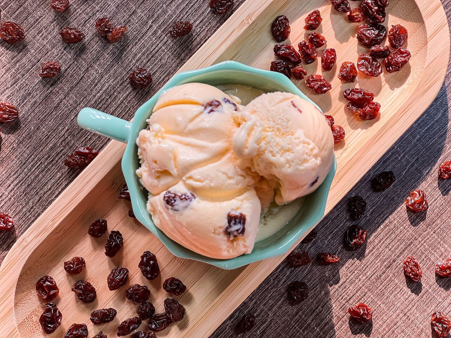 Bolas de sorvete cremoso com frutas por cima, servidas em travessa verde