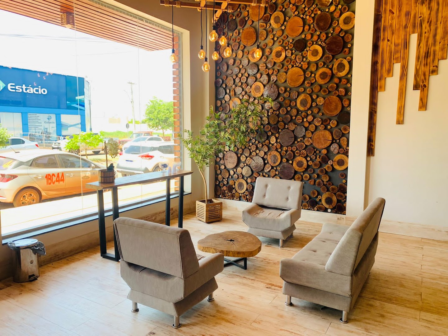 Lounge com parede de fatias de madeira e poltronas creme