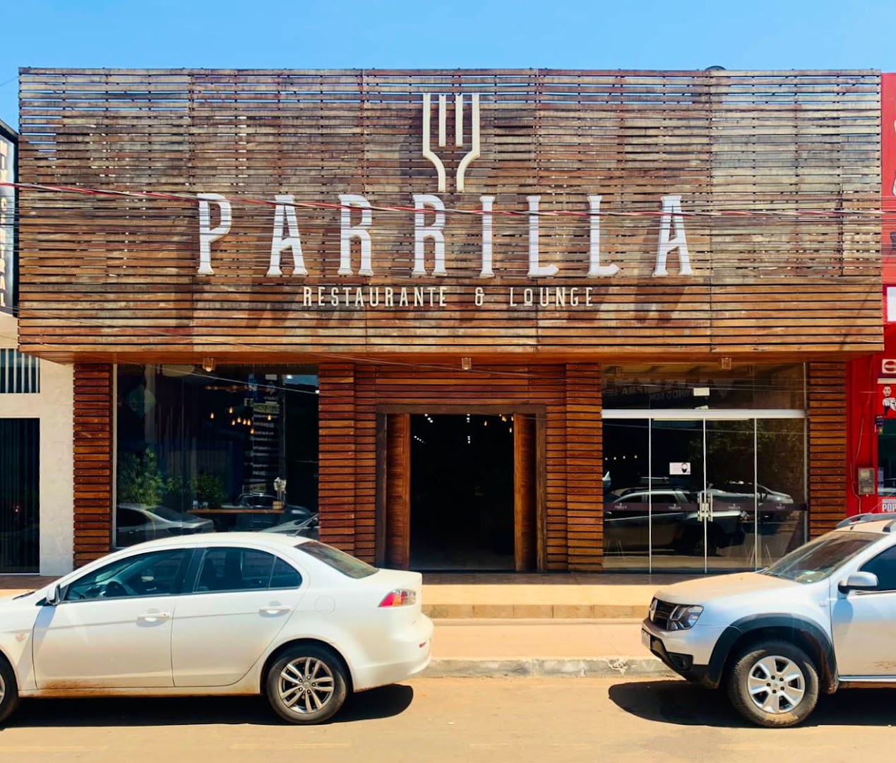 Fachada da Parrilla em madeira com o letreiro Restaurante e Lounge