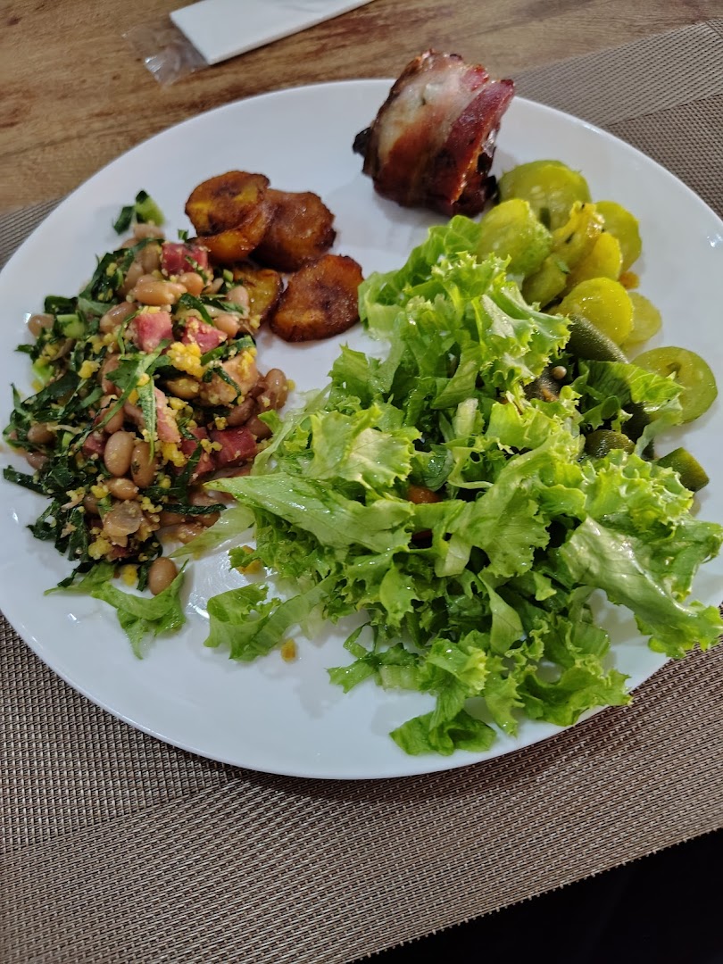 Prato montado com salada verde fresca, feijão tropeiro, banana e carne