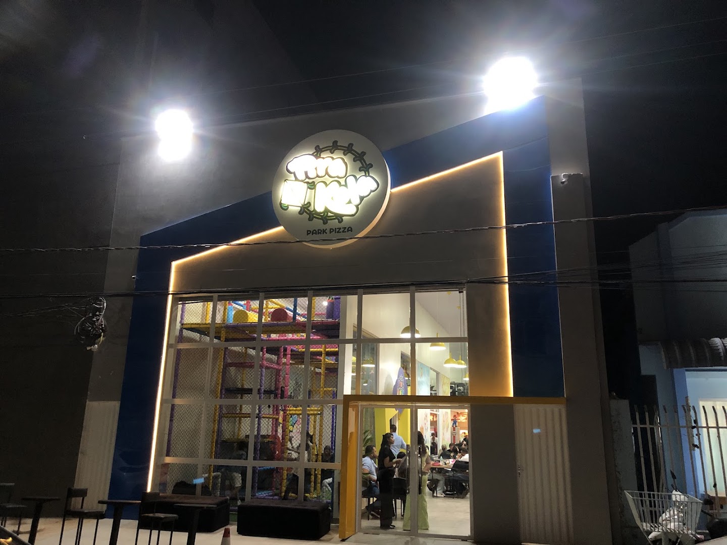 Fachada moderna e iluminada da Pirakola Park Pizza à noite