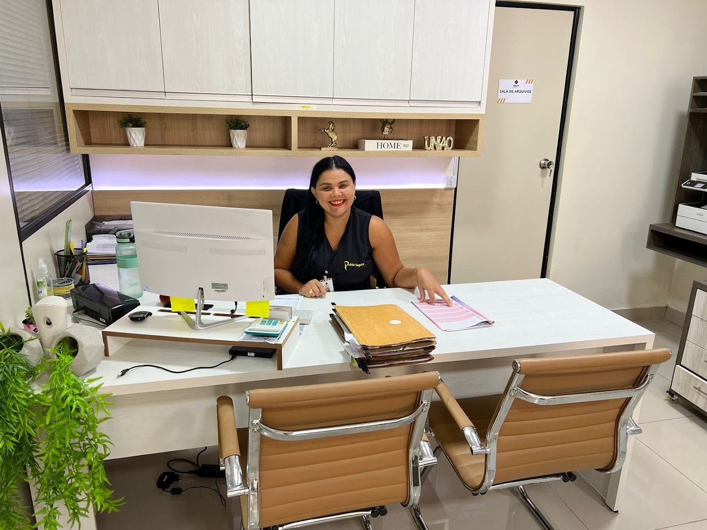Corretora atendendo na mesa dentro da Prévia Seguros