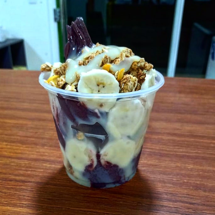 Copo de açaí com granola, banana e um fio de calda