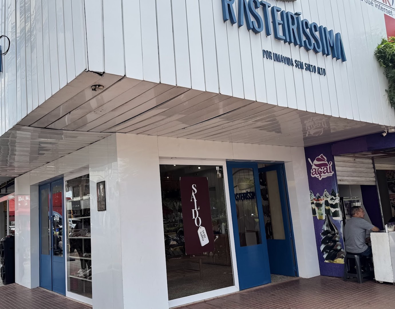 Fachada branca e azul da loja Rasteiríssima na Cidade Nova