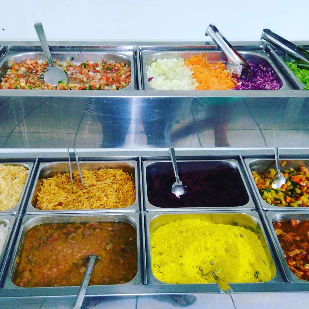 Balcão de self-service com cubas de saladas e pratos variados
