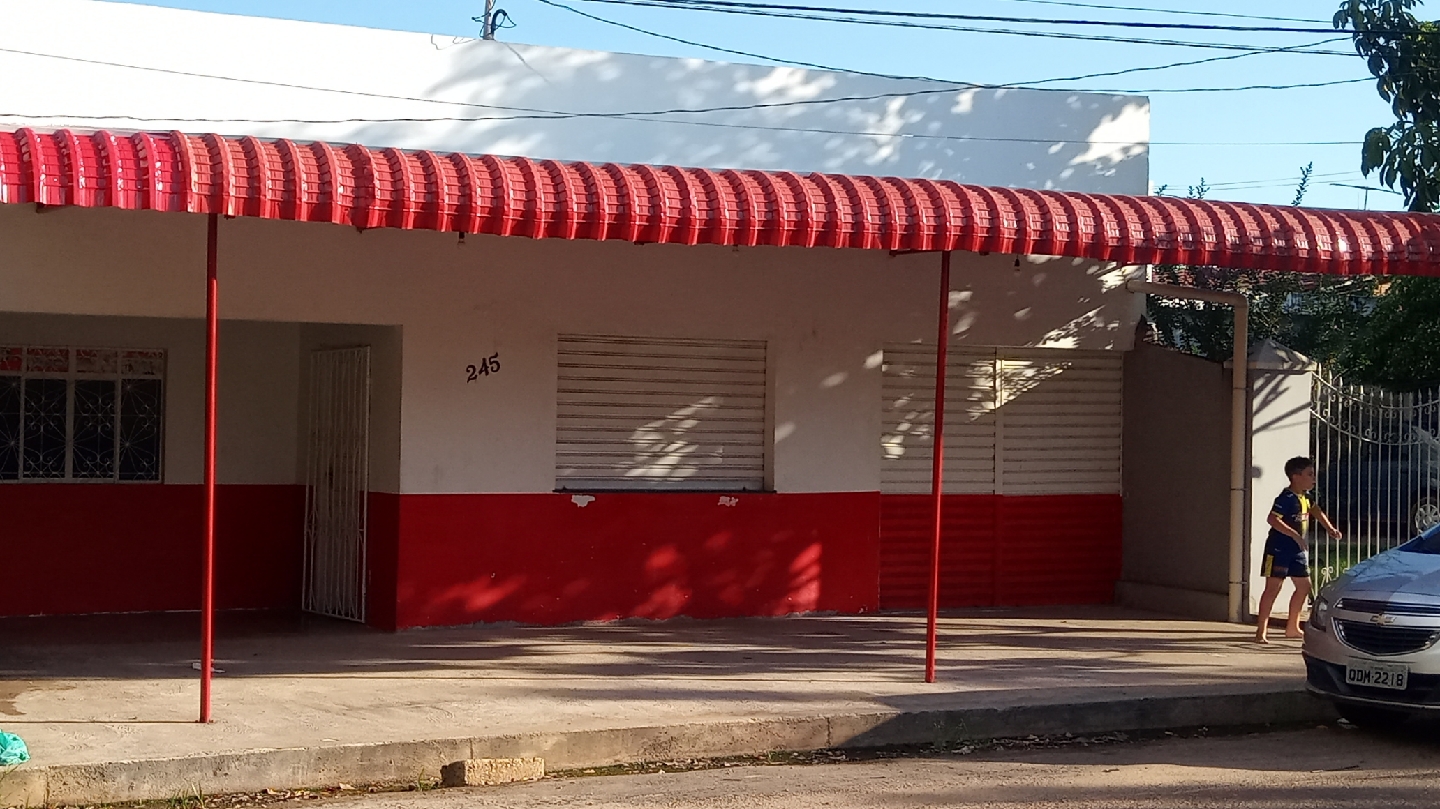 Fachada do restaurante vista da rua, com toldo vermelho e o número 245