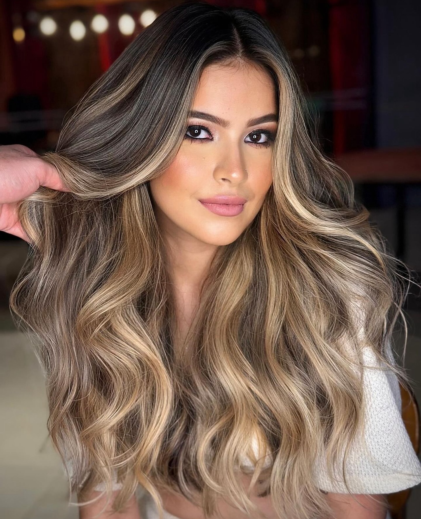 Cliente do Rose Resende com loiro iluminado e ondas volumosas