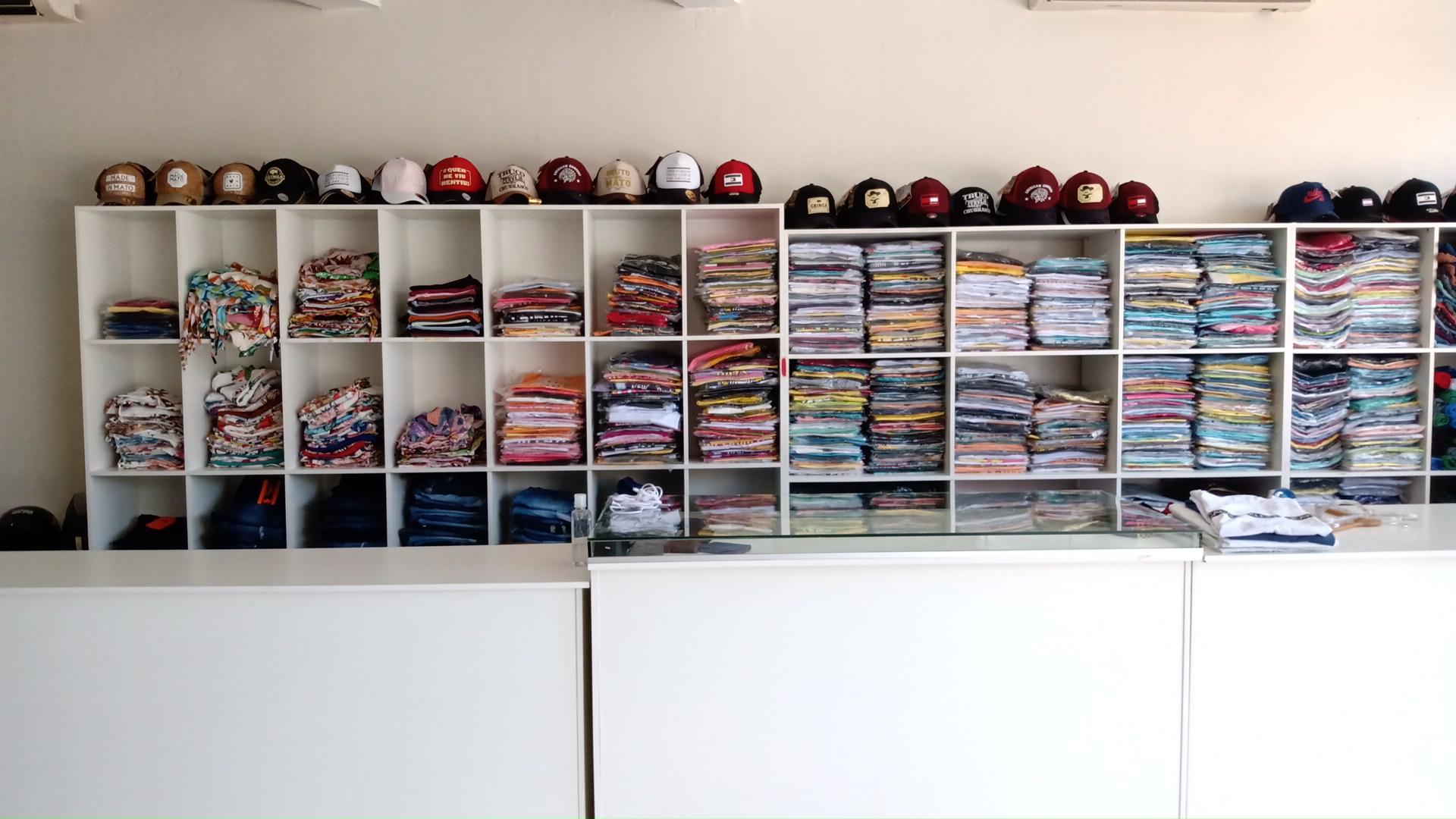 Prateleiras de roupas dobradas e bones organizados