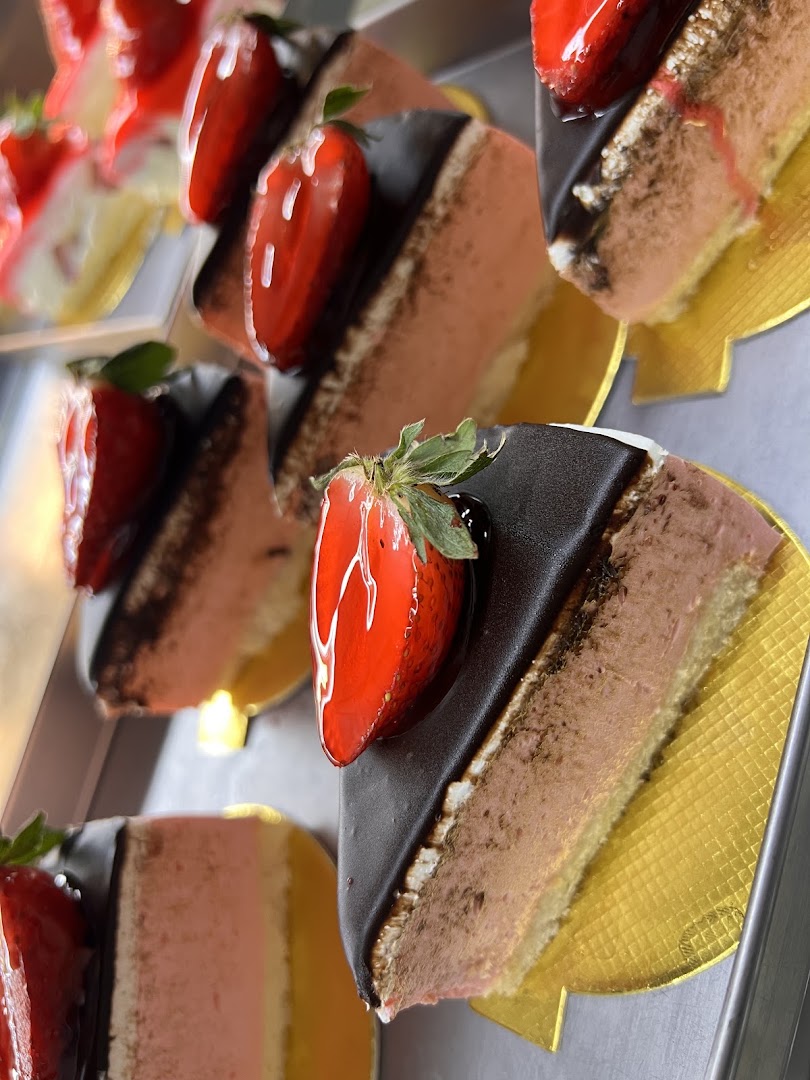 Fatias de tortas e bolos em camadas com morango, expostos na confeitaria