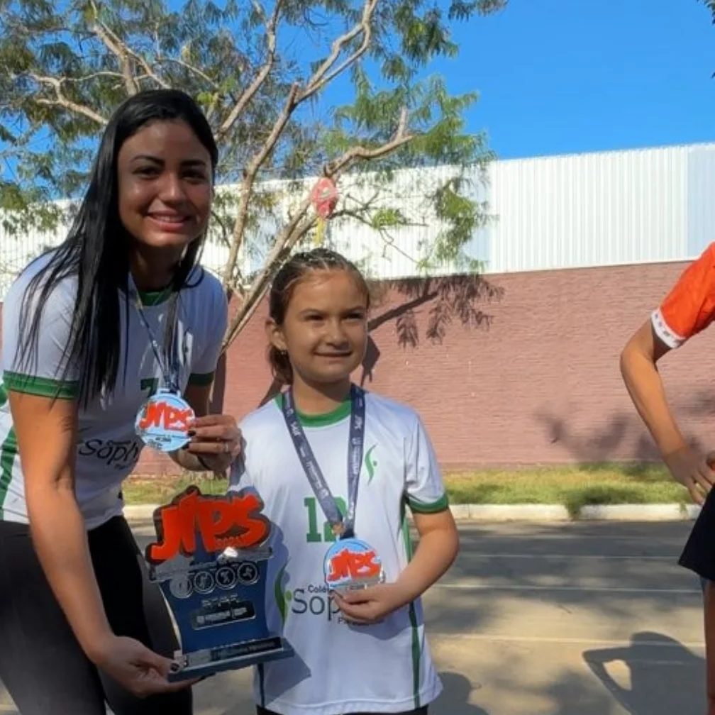 Aluna recebendo troféu na quadra