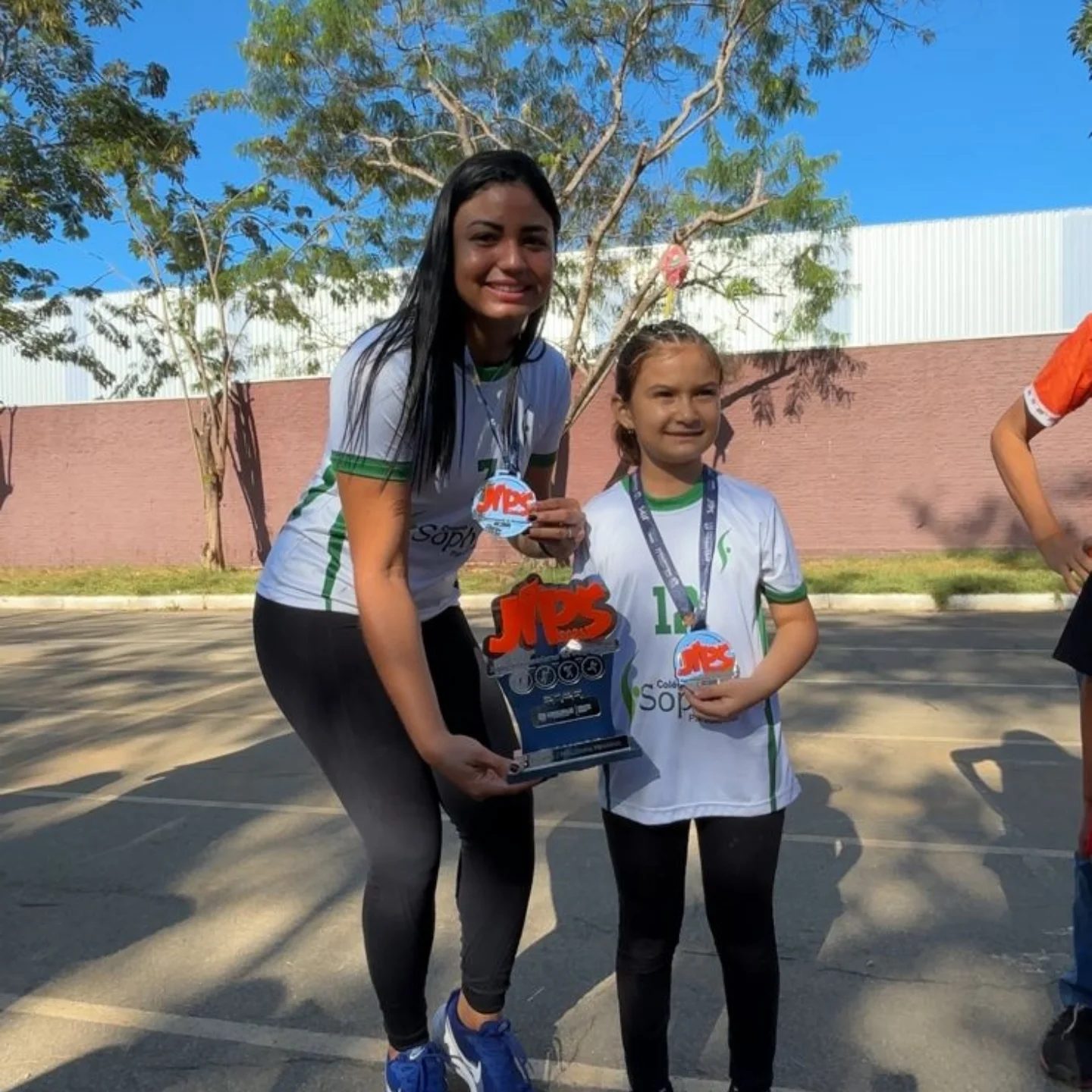 Aluna recebendo troféu na quadra