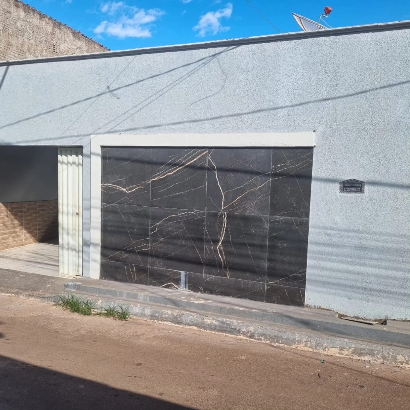Fachada de casa com portão de mármore preto