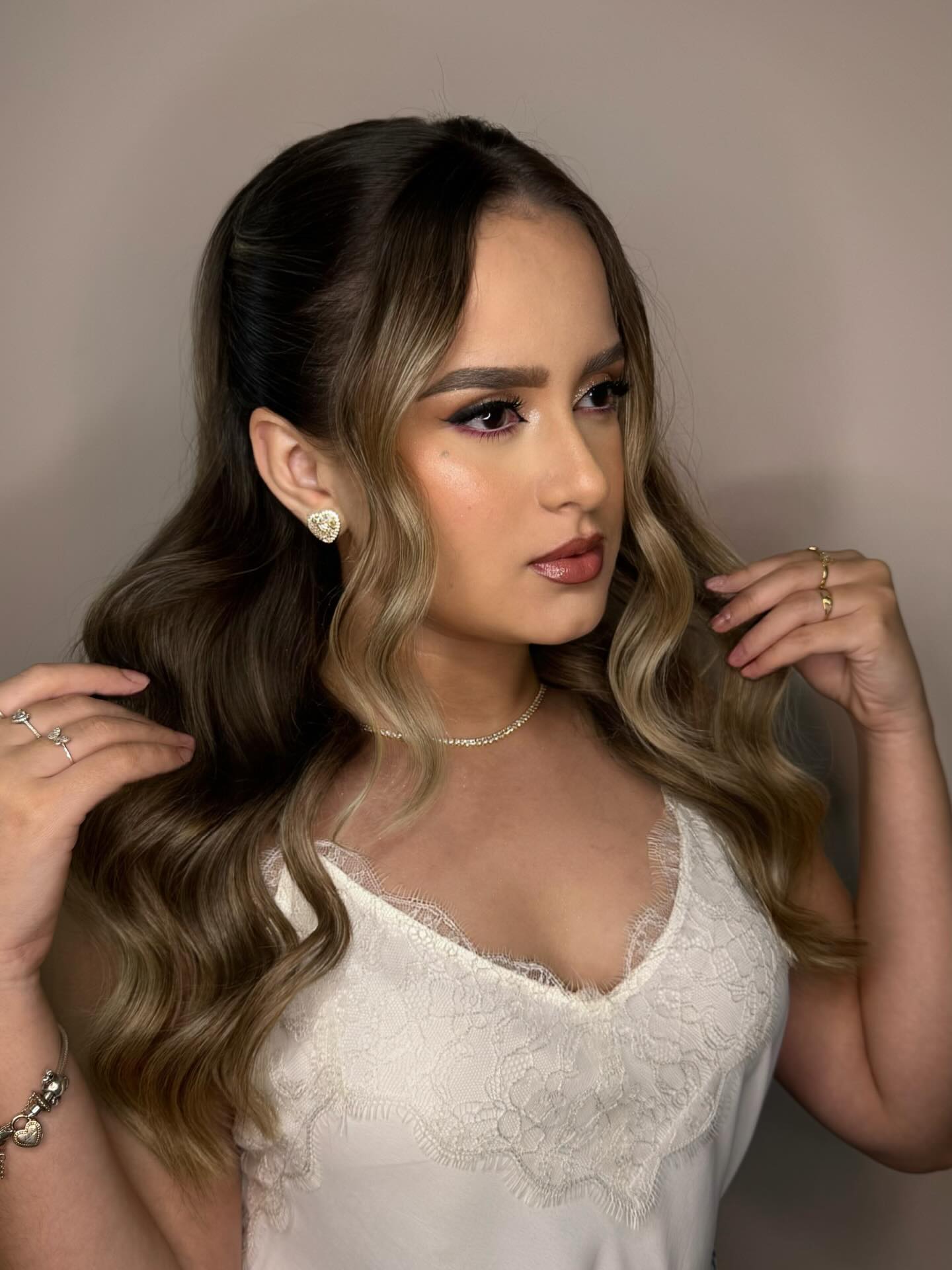 Cliente com penteado ondulado e maquiagem glam para evento