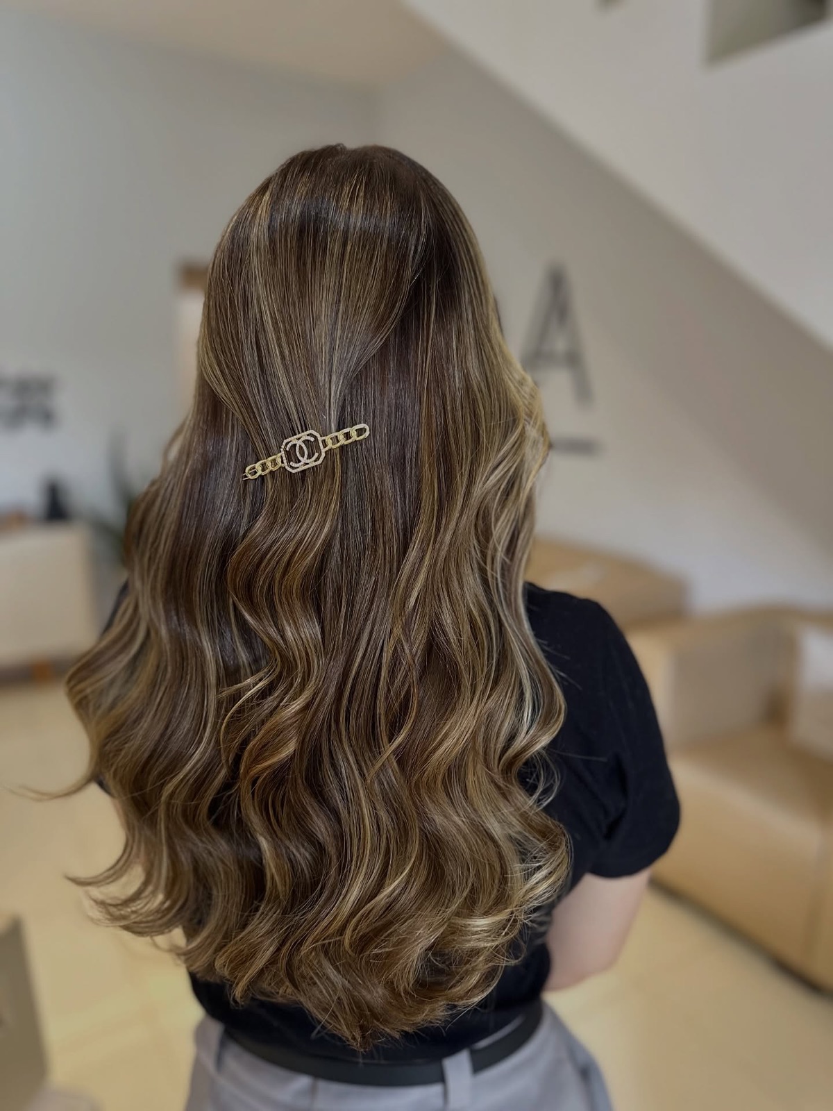 Balayage caramelo em cabelo longo com ondas e presilha dourada