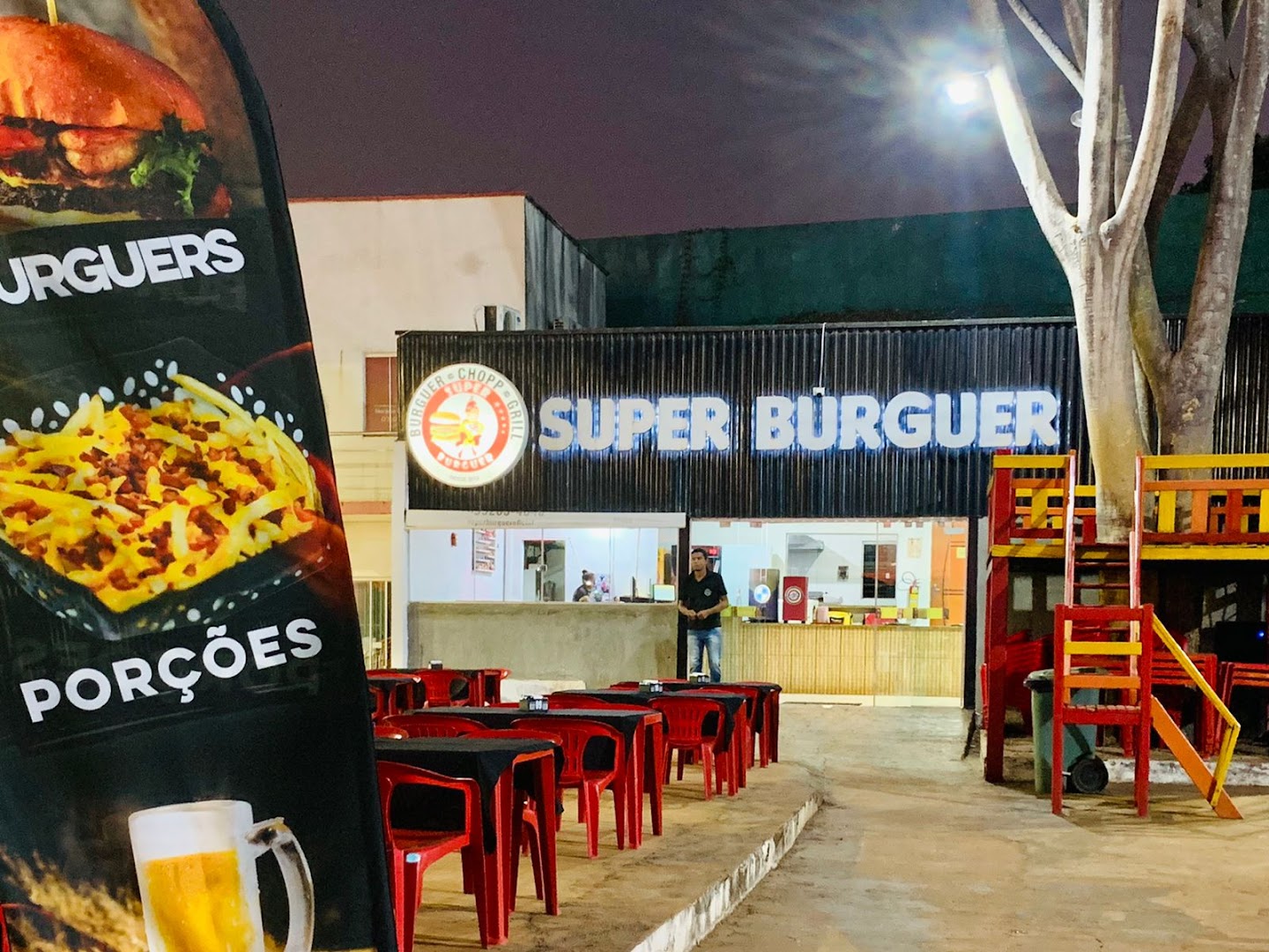 Fachada e salão da Super Burguer com mesas pra comer no local