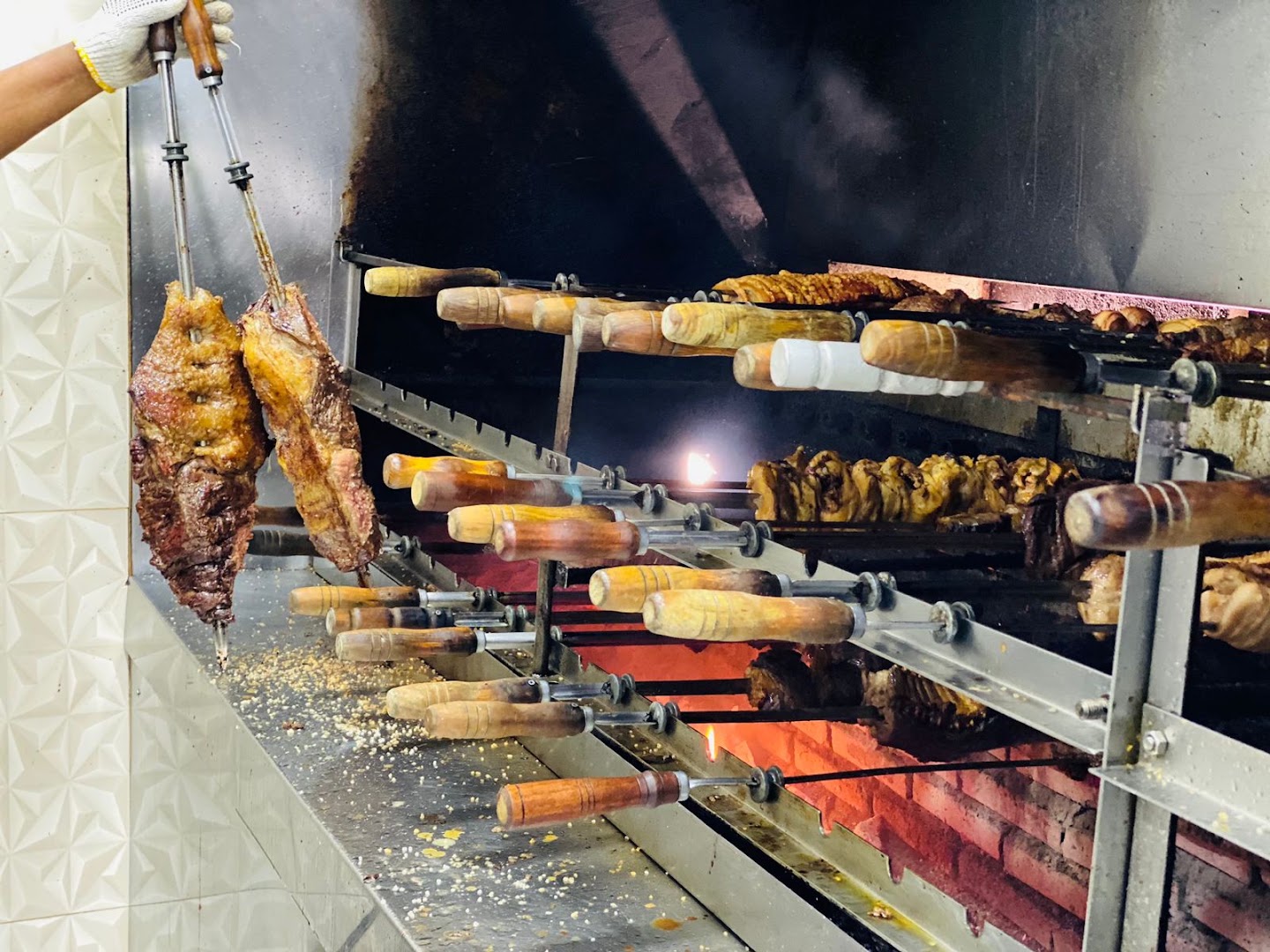 Espetos de carne assando na brasa da churrascaria