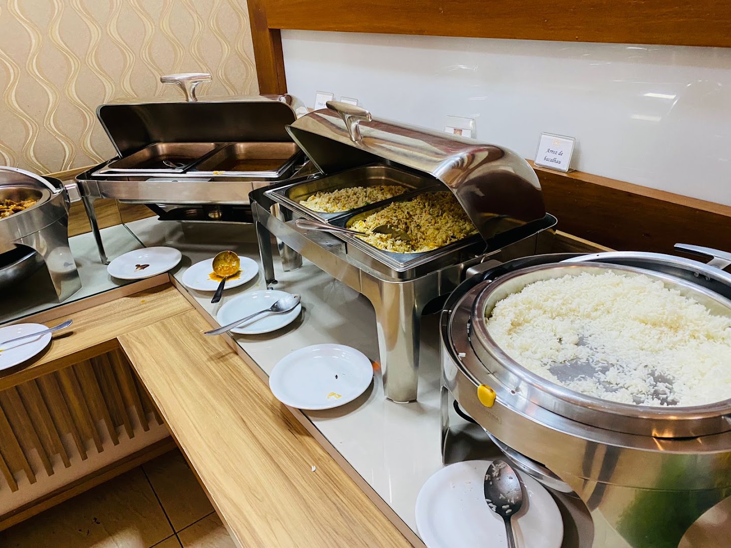 Cubas com pratos quentes, arroz e feijão no buffet