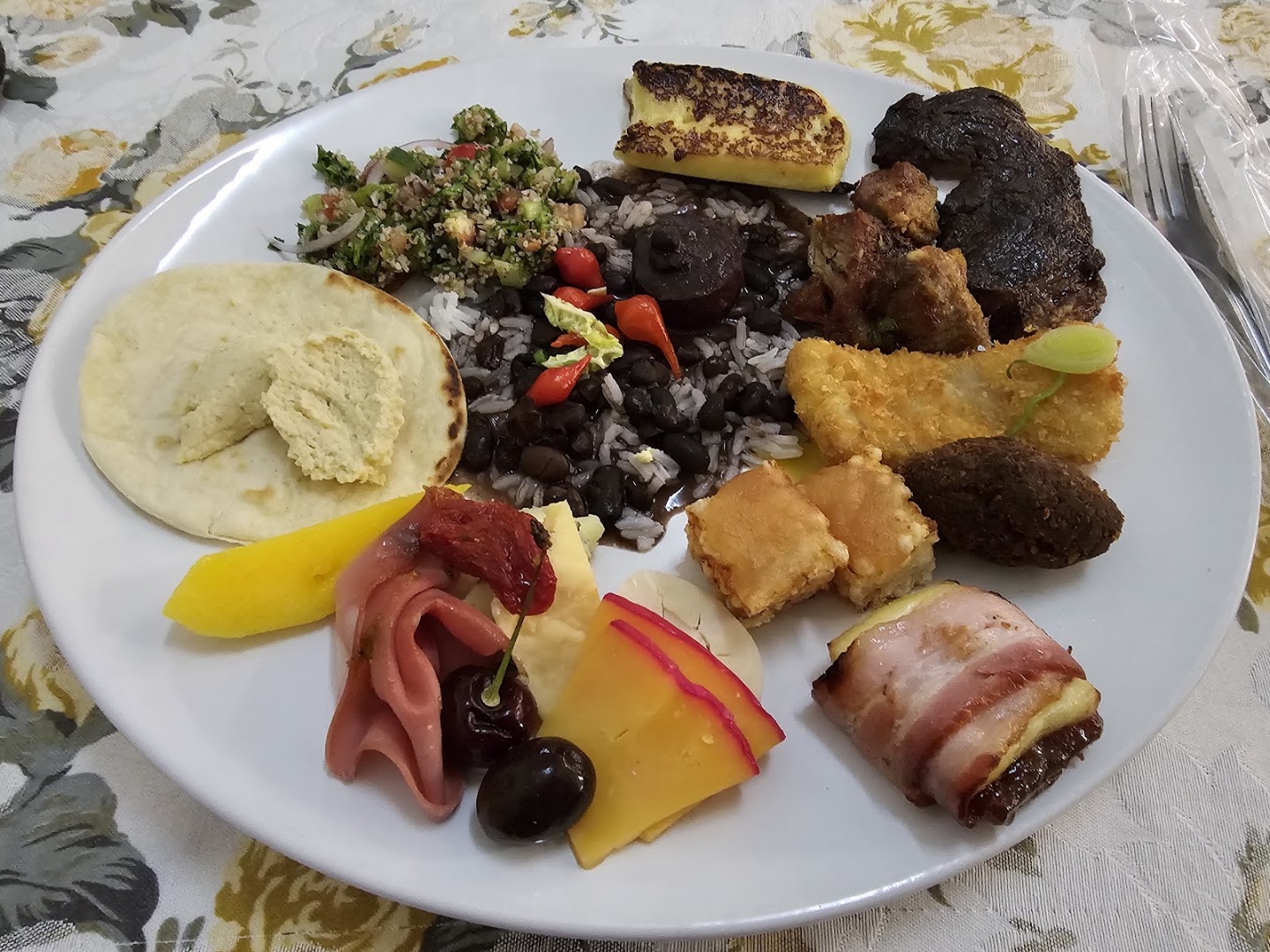 Prato montado com churrasco, feijão e acompanhamentos
