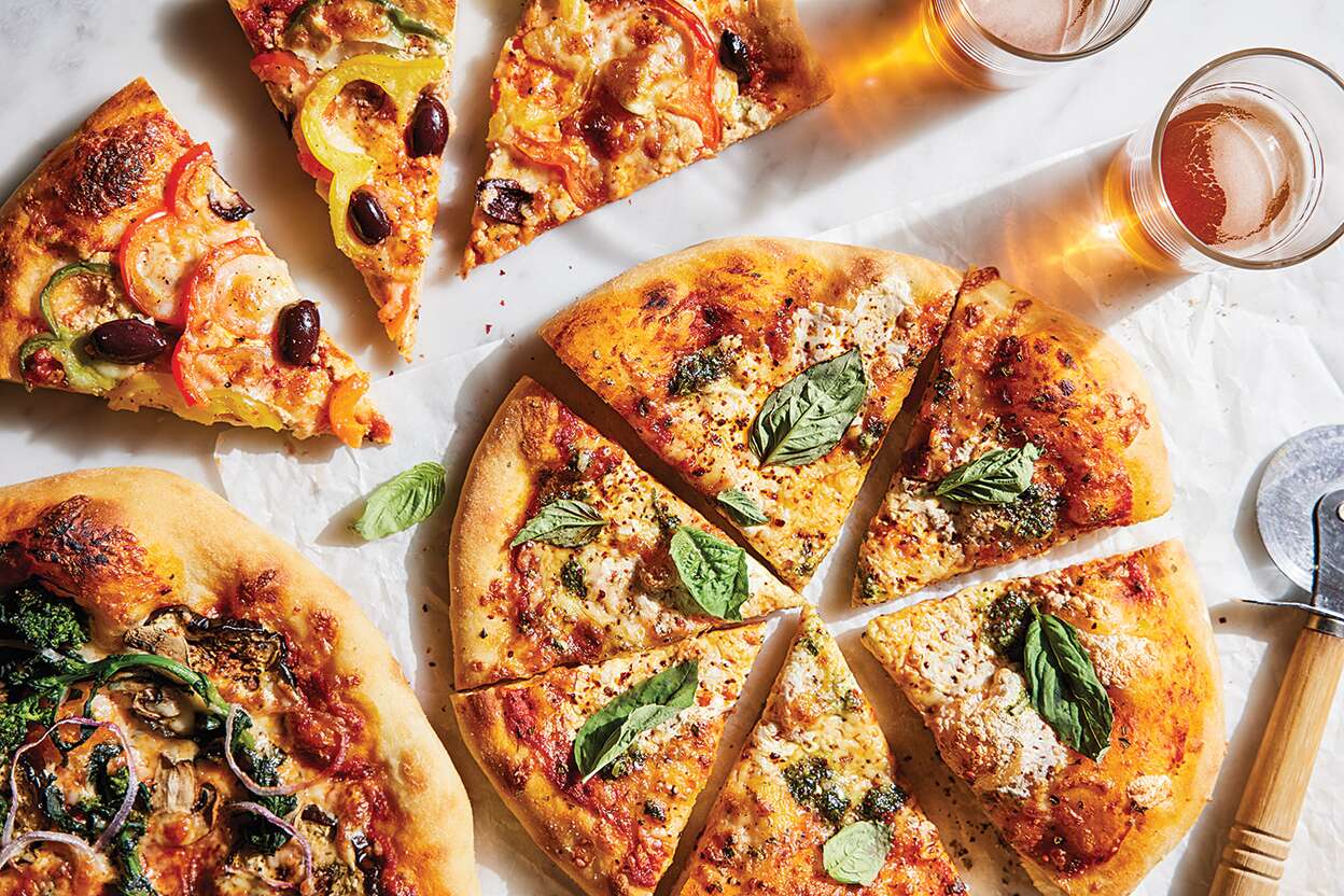 Pizza inteira fresca com manjericão saindo do forno