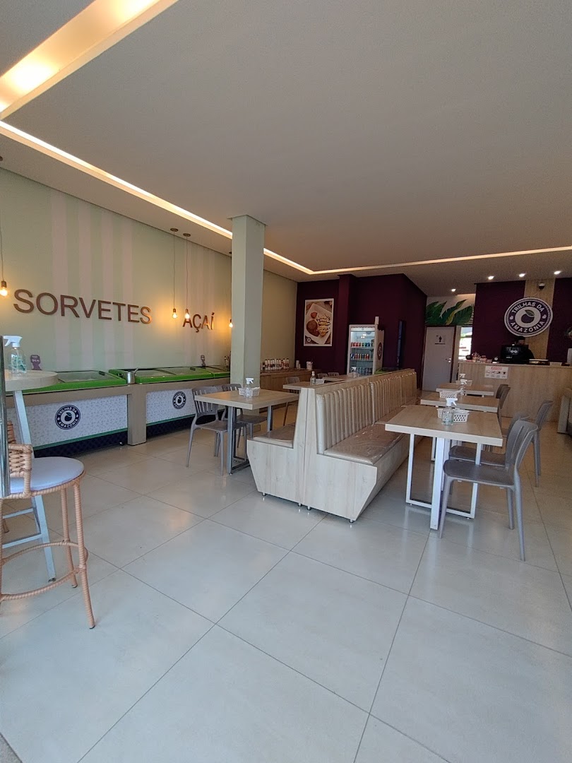 Salão da sorveteria com mesas e freezers