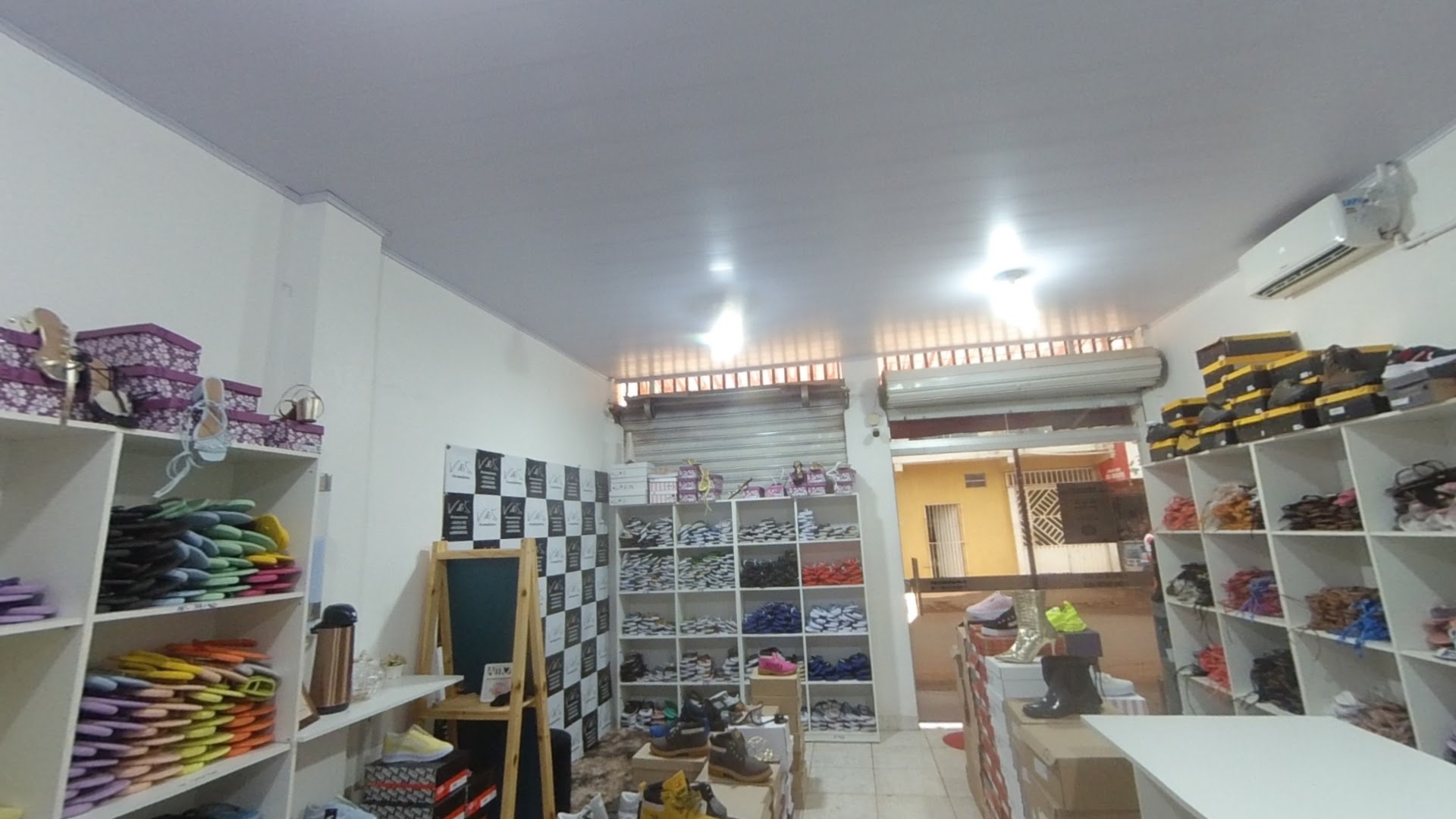 Interior da loja V&S, com prateleiras de calçados