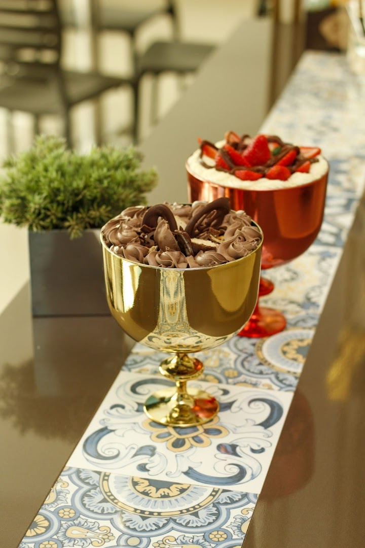 Sobremesas em taças douradas com mousse e morango